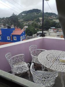 a table and chairs on a balcony with a view at Casa Lila in Mineral del Monte +5 photos