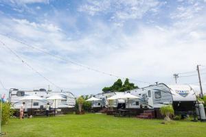 um grupo de caravanas estacionadas num campo de relva em Natural farm Zanpa -SEVEN Hotels and Resorts- em Yomitan