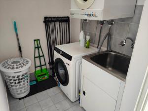 een kleine keuken met een wasmachine en een wastafel bij Tuggeranong Short Stay #07C - Sleeps 6 in Canberra