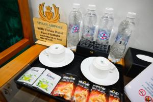 a table topped with plates and bottles of water at Vivian Airport Hotel Saigon in Ho Chi Minh City