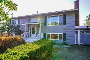 a white house with a porch and a door at Seatac 2 BR Upper Unit 5 min to Airport in SeaTac