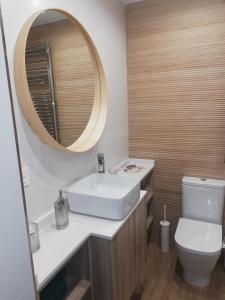 uma casa de banho com um lavatório, um espelho e um WC. em Apartamento de lujo mirando al mar VUT-3354AS em Salinas