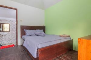 1 dormitorio con 1 cama y lavamanos. en Bale Gantar en Sembalunlawang