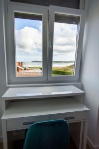 uma secretária com uma janela e uma cadeira azul em Apartamento de lujo mirando al mar VUT-3354AS em Salinas