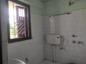 a bathroom with a toilet and a window at Duda Lodge in Tezu