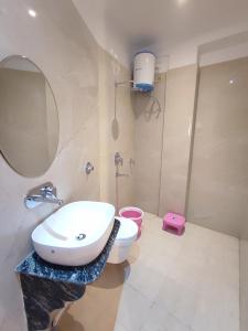 a bathroom with a sink and a toilet and a mirror at S.S Guest House in Varanasi