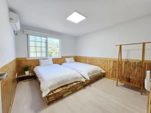 a bedroom with a bed and a window at Baerongnamu Private Stay in Seogwipo