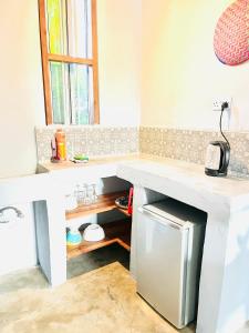 a kitchen with a counter top and a refrigerator at Butterfly Apartment Zanzibar in Bwejuu