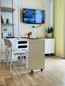 a kitchen with a table and a tv on the wall at Thóc Ecopark blue home-1 bed room in Cong Luận