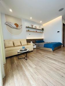 a living room with a couch and a bed at Thóc Ecopark blue home-1 bed room in Cong Luận