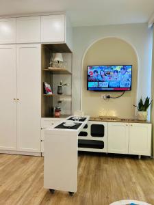 a kitchen with a stove and a tv on the wall at Thóc Ecopark blue home-1 bed room in Cong Luận