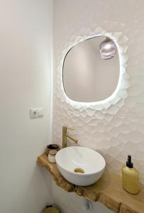 a bathroom with a white sink and a mirror at La posada de Calixto in Valdepeñas