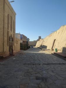 an empty street in an alley next to some buildings at Mubina Khiva B&B in Khiva