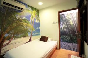a bedroom with a bed with a palm tree mural at Rain Forest Hotel in Kuala Lumpur