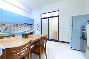 a kitchen with a wooden table and a refrigerator at Sunshine B&B in Hualien City