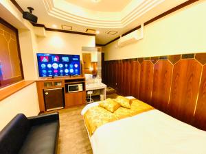 um quarto de hotel com uma cama e uma televisão de ecrã plano em Hotel Crystal 大人専用 em Tóquio