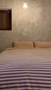 um quarto com uma cama com um cobertor listrado em Daughter and son em Jinhu