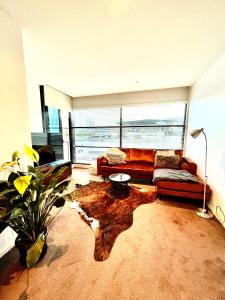 a living room with a couch and a tree stump coffee table at Luxurious Apartment in the heart of Docklands in Melbourne