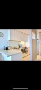 a kitchen with white cabinets and a white counter top at Luxurious Apartment in the heart of Docklands in Melbourne