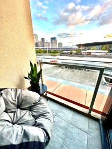 a balcony with a couch and a view of a pool at Luxurious Apartment in the heart of Docklands in Melbourne