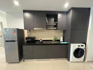 a kitchen with a refrigerator and a washing machine at Encorp Marina, 2 Bedroom, 6pax, Same Floor with Indoor Infinity Pool in Nusajaya
