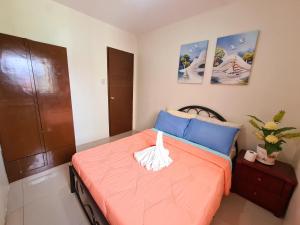 a small bedroom with a bed with orange sheets at Fully Furnished Apartment with Netflix and Wifi in Batangas City