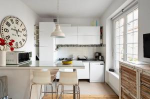 eine Küche mit weißen Schränken und einem Tisch und Stühlen in der Unterkunft Appartement Au Coeur D'intra Muros in Saint-Malo