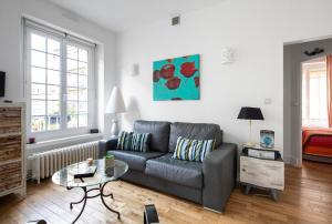 ein Wohnzimmer mit Sofa und Tisch in der Unterkunft Appartement Au Coeur D'intra Muros in Saint-Malo