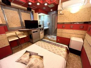 1 dormitorio con 1 cama en una habitación con paredes rojas en Hotel Crystal 大人専用, en Tokio