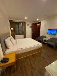 um quarto com uma cama grande e uma sala de estar em Khách Sạn A83Hotel em Hanói