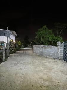 uma rua à noite com uma parede de pedra em B house em Thôn Hòa Ða
