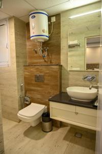 uma casa de banho com um WC, um lavatório e um espelho. em mountain crest em Solan