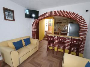 ein Wohnzimmer mit einem Backsteinbogen und eine Küche in der Unterkunft Casa Ángeles de Paxtitlàn in Guanajuato