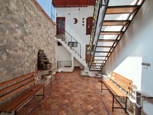 einen Flur mit Bänken und Treppen in einem Gebäude in der Unterkunft Casa Ángeles de Paxtitlàn in Guanajuato