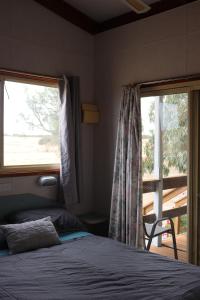 a bedroom with a bed and a large window at Coodlie Park Eco Retreat in Talia