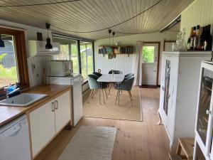 uma cozinha e sala de jantar com mesa e cadeiras em Charmerende Hus Med Havudsigt - 200m Fra Havet em Nykobing Sjaelland