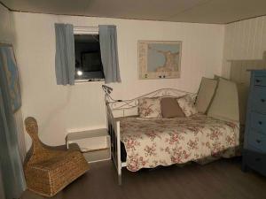 um quarto com uma cama, uma janela e uma cadeira em Charmerende Hus Med Havudsigt - 200m Fra Havet em Nykobing Sjaelland