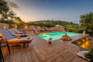 un patio trasero con piscina y terraza de madera en Vasia's Artistsvillas, en Gáios