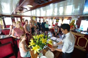 un grupo de personas de pie alrededor de una mesa en un barco en Halong Bay Full Day Trip - 6 Hours Route, en Ha Long