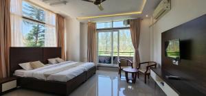 カスホールナガーにあるMazra Retreat, Coorg Kushālnagarのベッドルーム1室(ベッド1台、大きな窓付)