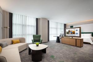 a hotel room with a television and a bed at Hilton by Hampton Guangzhou Xintang in Zengcheng