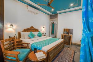 Schlafzimmer mit einem Bett, einem Tisch und Stühlen in der Unterkunft AAJ HAVELI - Lake Facing Boutique Hotel by Levelup Hotels in Udaipur