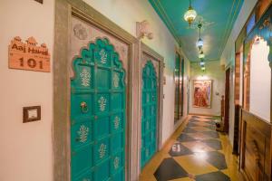 a hallway with a green door and a tile floor at AAJ HAVELI - Pichola Lake Facing Hotel in Udaipur