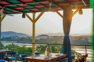 a restaurant with tables and chairs and a view of a river at AAJ HAVELI - Lake Facing Boutique Hotel by Levelup Hotels in Udaipur