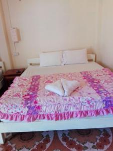 a bed with two pillows on top of it at sainamhoun guesthouse in Ban Sôphoun +3 photos