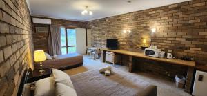 ein Wohnzimmer mit Ziegelwand in der Unterkunft Magdala Motor Lodge & Lakeside Restaurant in Stawell