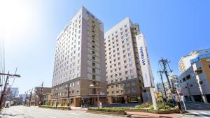 un edificio alto en una calle de una ciudad en Toyoko Inn Takasaki eki Nishi guchi No 2, en Takasaki