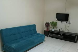 un sofá azul en la sala de estar con TV en Homestay Itqan Seri Iskandar en Seri Iskandar