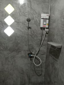 a shower with a hose attached to a wall at Cha Bungalow in Ko Yao Noi