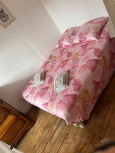 eine rosa Bettdecke auf einem Bett in einem Zimmer in der Unterkunft Cottage viva la vida in Auzon